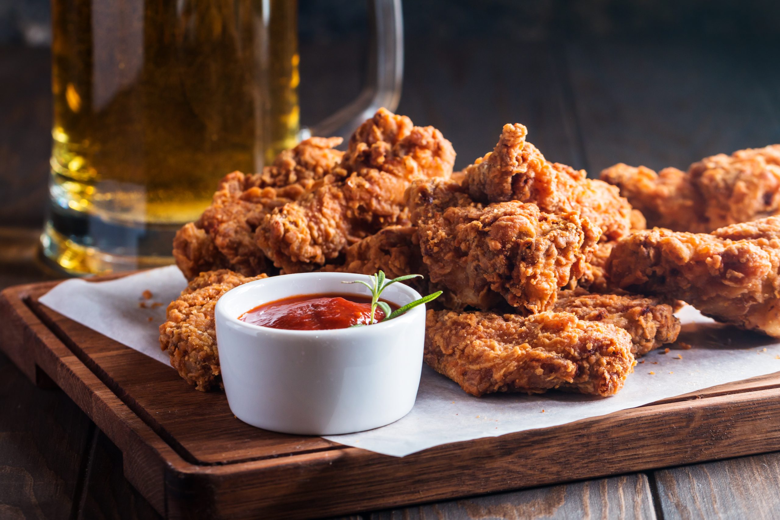 Buffalo style chicken wings served with cold beer on wooden background